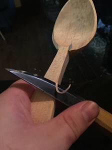 knife slicing the corner off a spoon handle